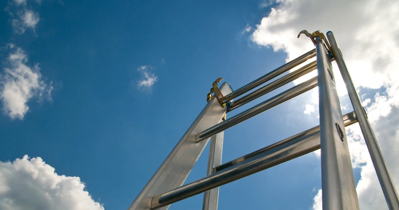 Escalera de aluminio extendida contra el cielo