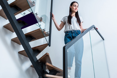 Mujer bajando una escalera agarrada al pasamanos