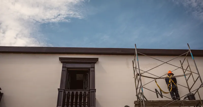 Andamio tubular de marcos junto a una fachada encalada